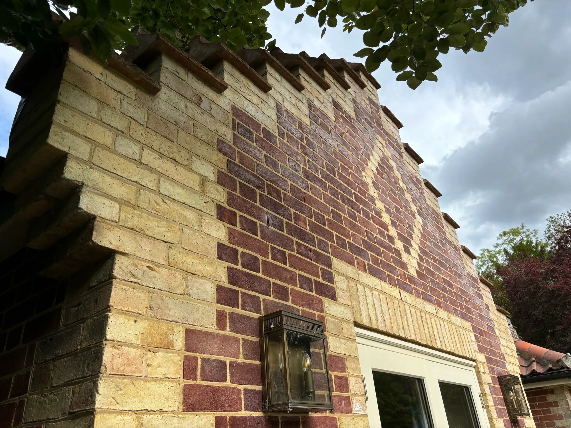 Diaper brick patterning and stepped parapet detail on the gable