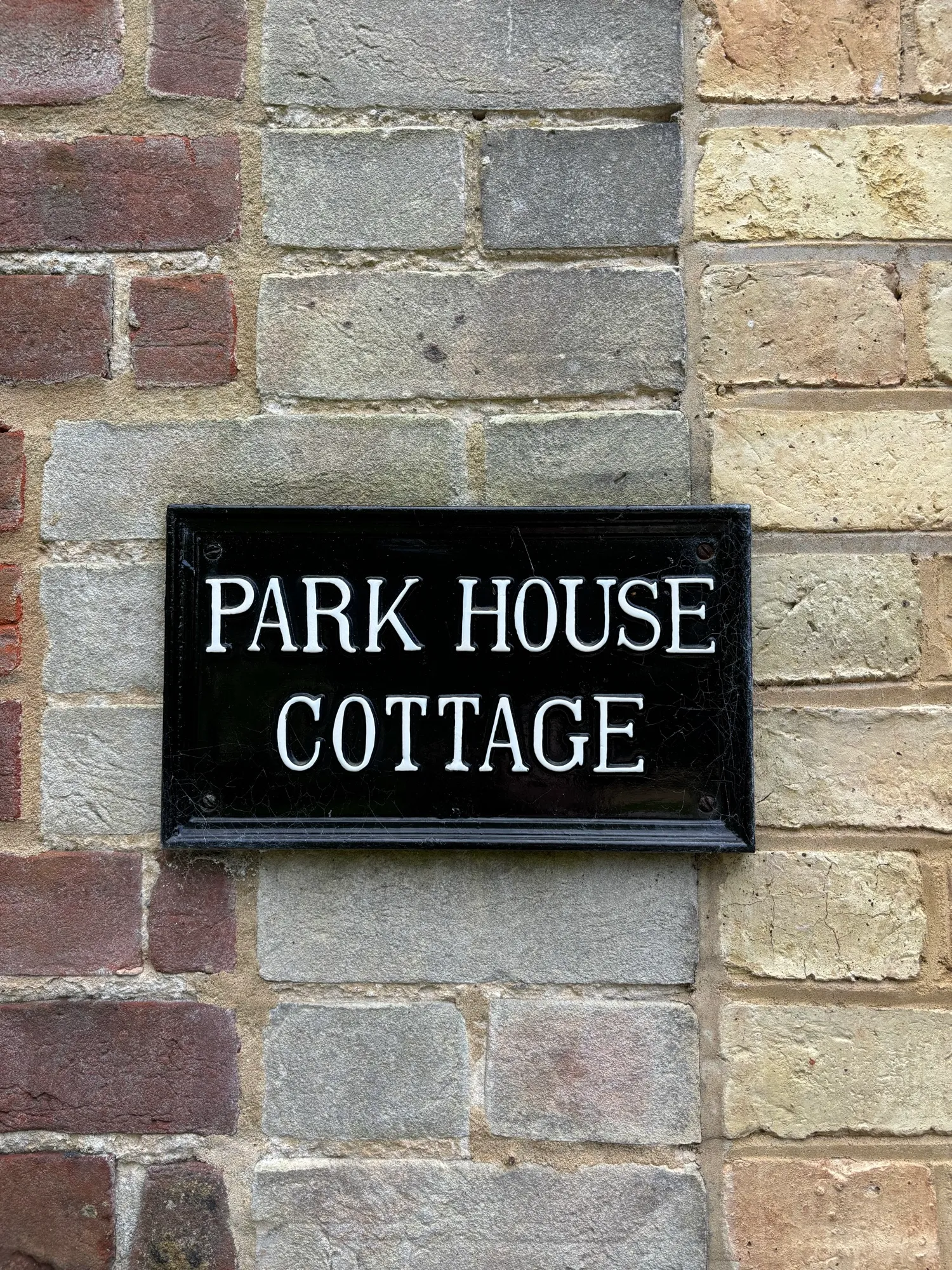 The Park House Cottage nameplate on the flint and brick wall